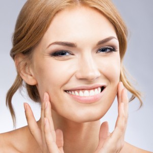 Young woman touching cheeks with middle finger of both hands