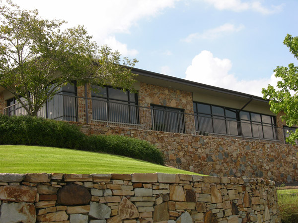 Surgery Center building with stone wall and wide windows with tree on the left