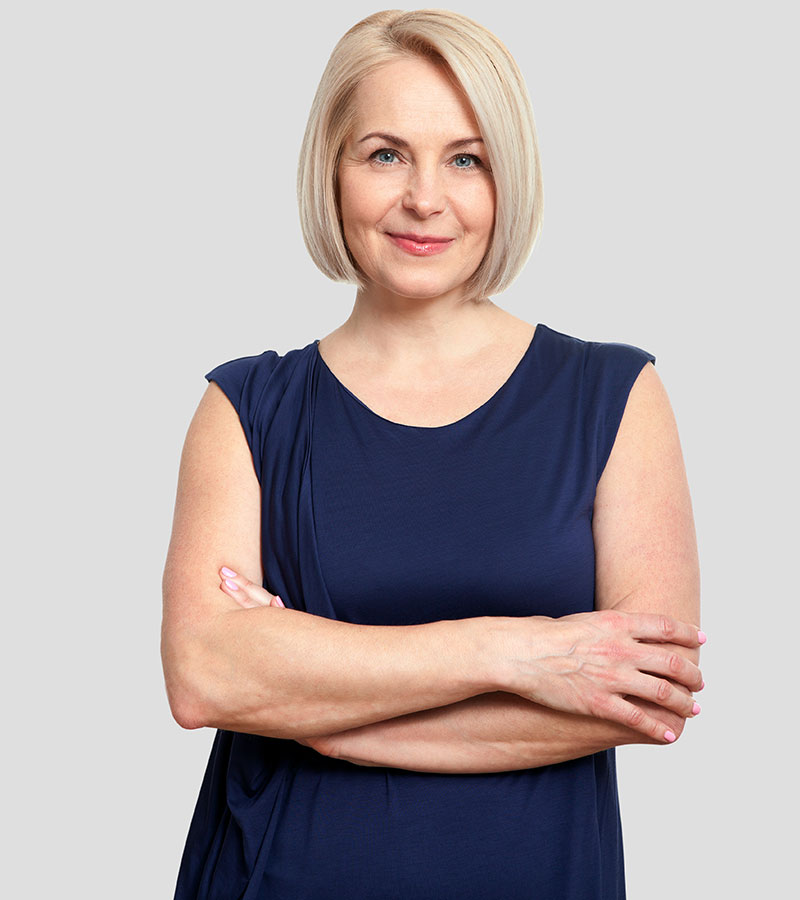 Happy Middle aged woman in a blue blouse crossing her arms