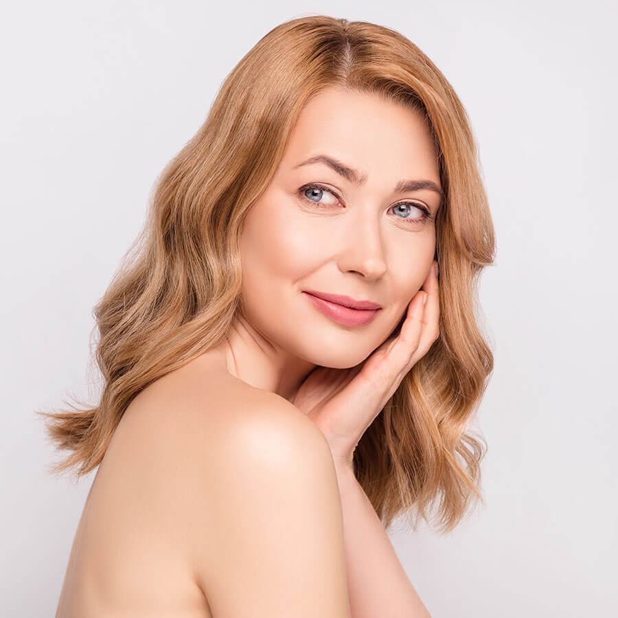 Woman hold her hand to her face and looking over her shoulder