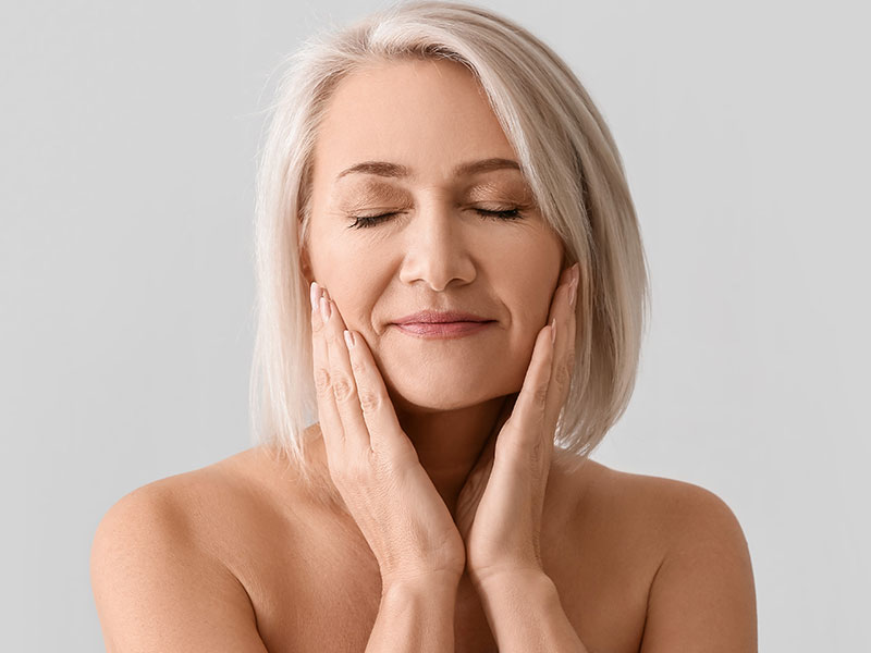 Mature woman touching her face