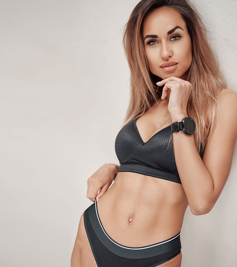 elegant woman leaning on wall and wearing undergarments