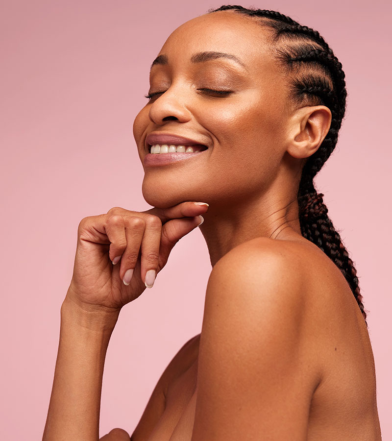 Adult Black woman with braids holding her finger to her chin